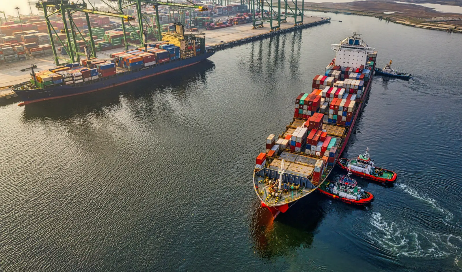 Container ship under tow into a Chinese container port, seen from the air
